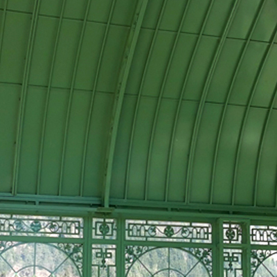 Inner arched steel roof and detailed decorative iron grille of greenhouse