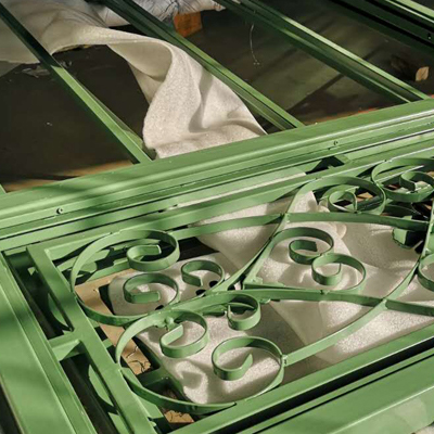 Close‑up of ornate scroll‑style steel window frames for conservatory