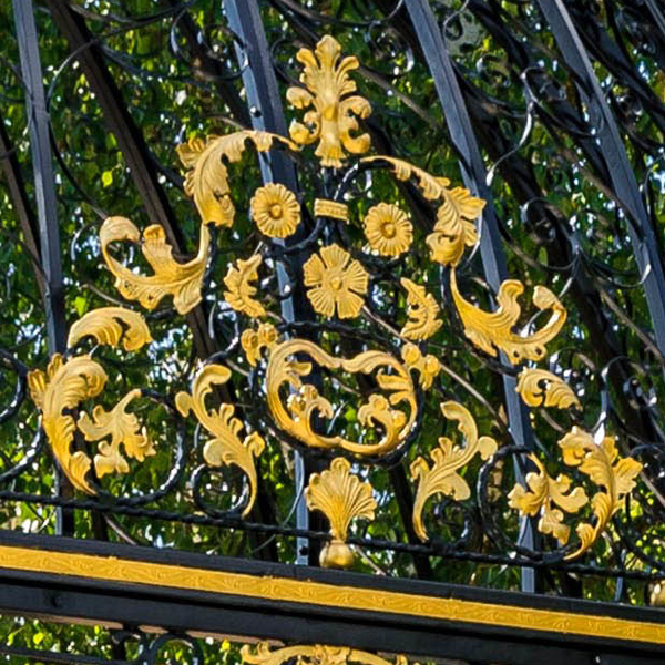 Close shot of golden floral scroll wrought iron decorative patterns on wedding gazebo frame