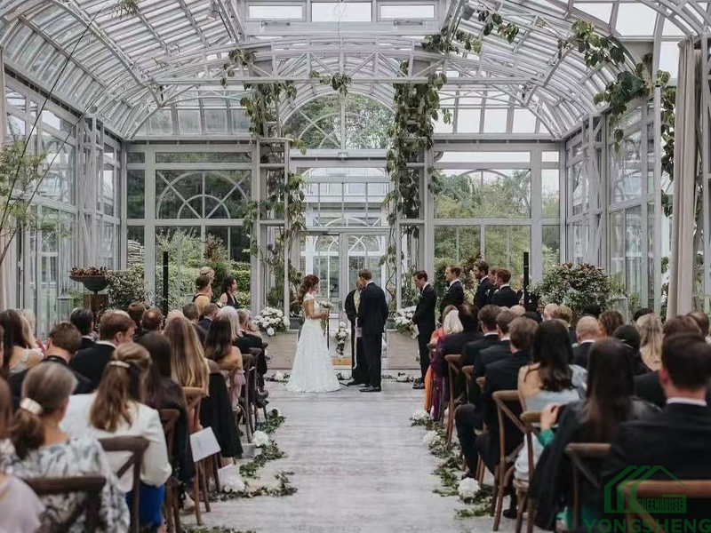 Wedding ceremony inside victorian glass conservatory with guests and floral decor