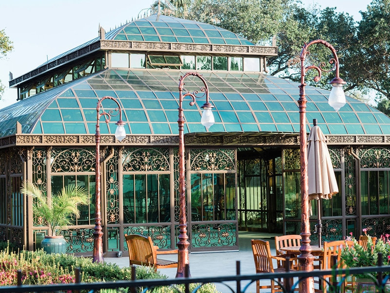 Victorian-style glass conservatory with steel frame and outdoor dining terrace.