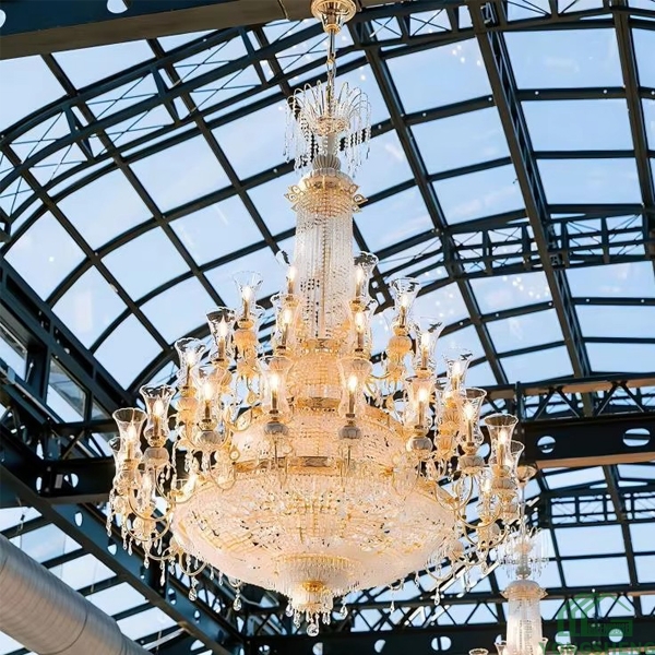 Grand crystal chandelier hanging from iron truss glass ceiling