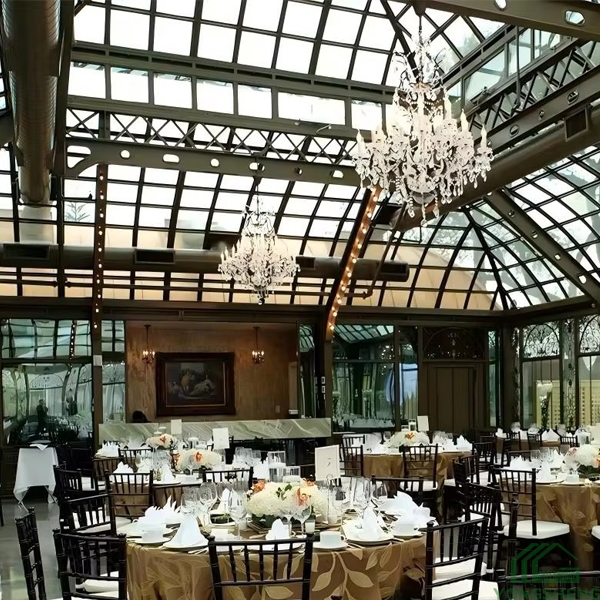 Glass sunroom decorated with crystal chandeliers for wedding dinner reception