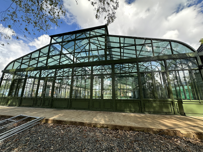 Exterior view of large Victorian curved glass greenhouse sunroom