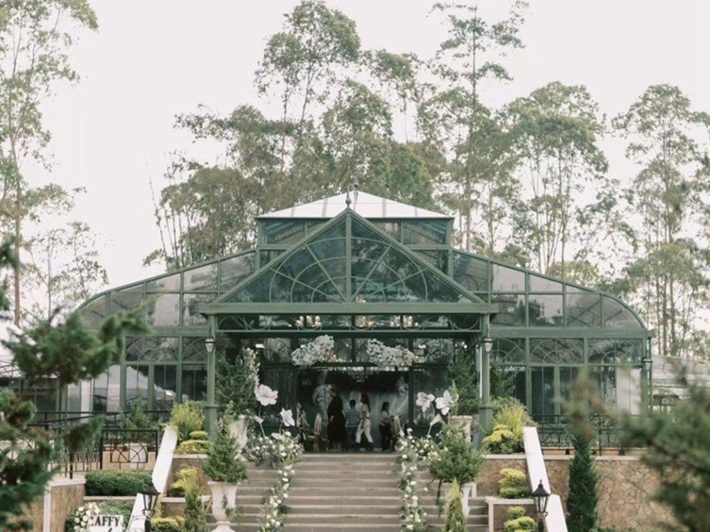 Exterior view of large victorian glass conservatory wedding venue with entrance stairway