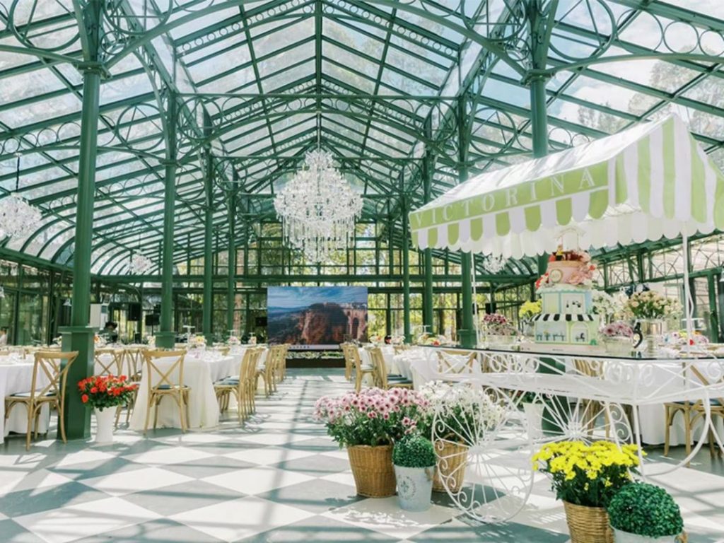 Bright victorian glass conservatory interior arranged for daytime wedding party event