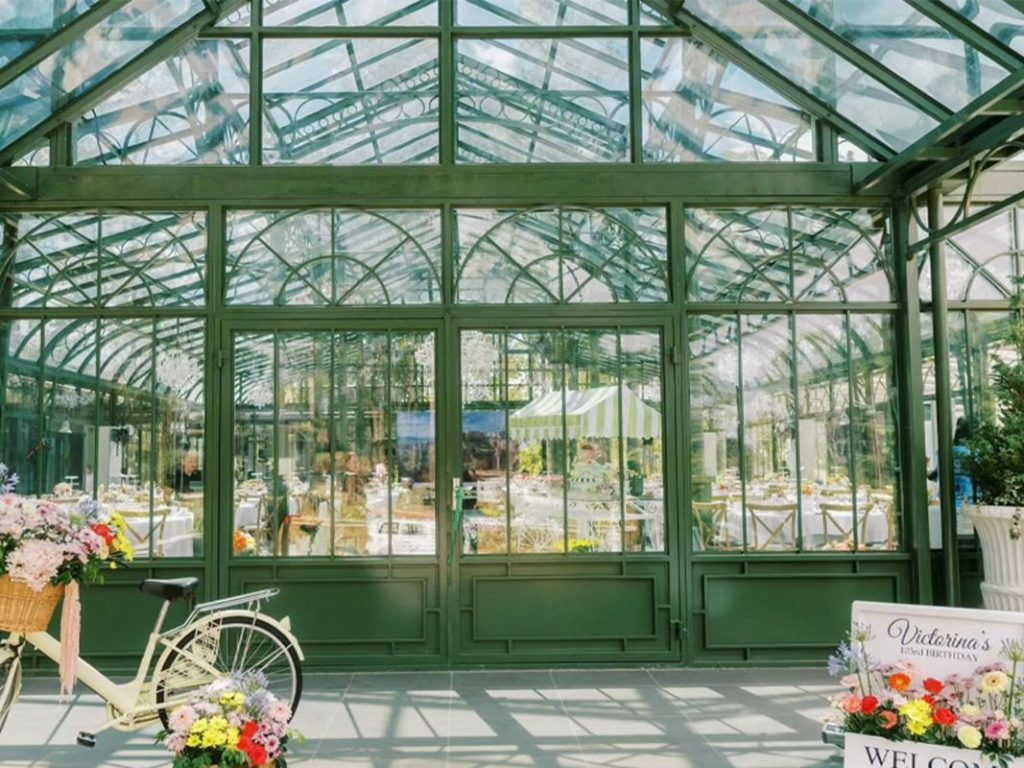 Front glass door facade of green victorian glass conservatory event venue