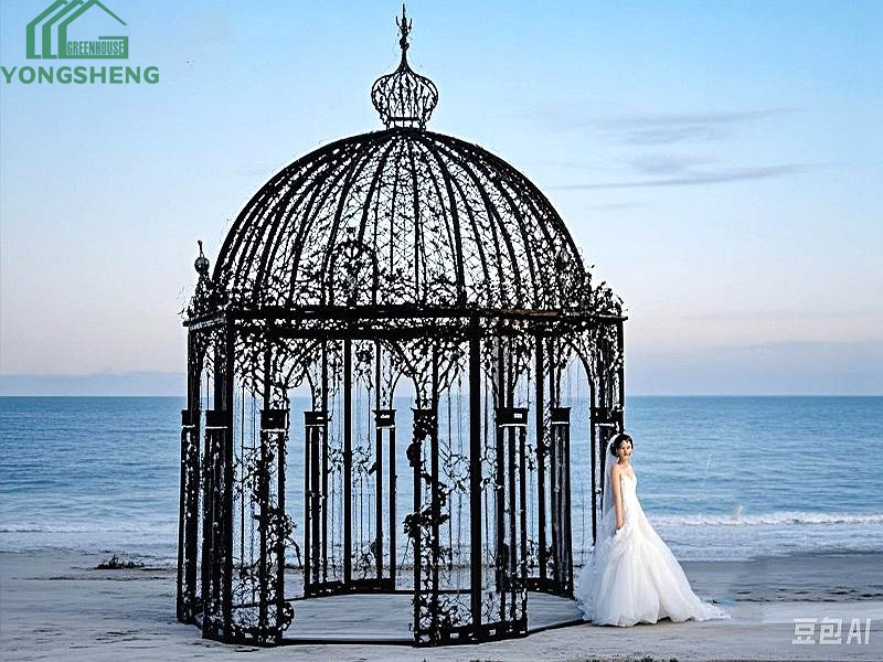 Black ornate dome metal wedding gazebo set on sandy beach for seaside wedding ceremony