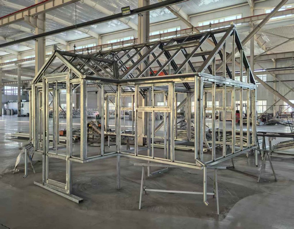 Unfinished raw steel frame of Victorian greenhouse inside factory workshop
