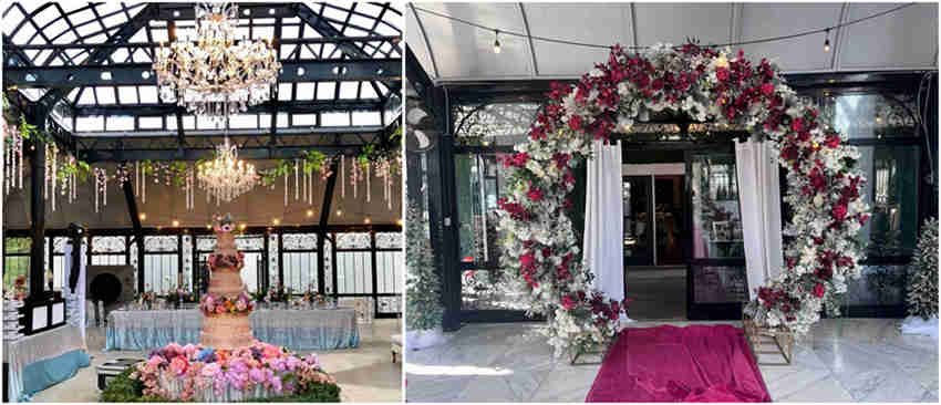A beautifully decorated Victorian greenhouse wedding setup with floral arches and soft lighting.