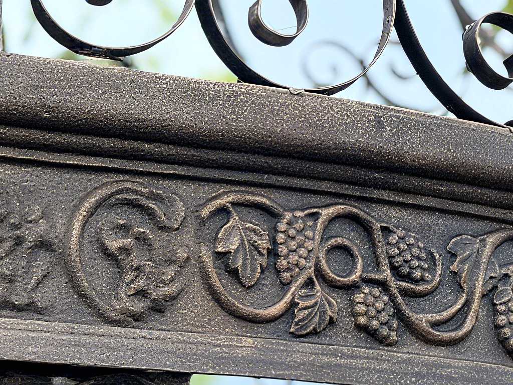 Close‑up view of grape vine relief carving on cast iron gazebo frame