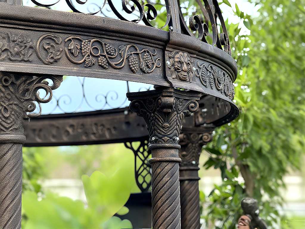 Twisted cast‑iron column and carved beam detail of vintage garden gazebo