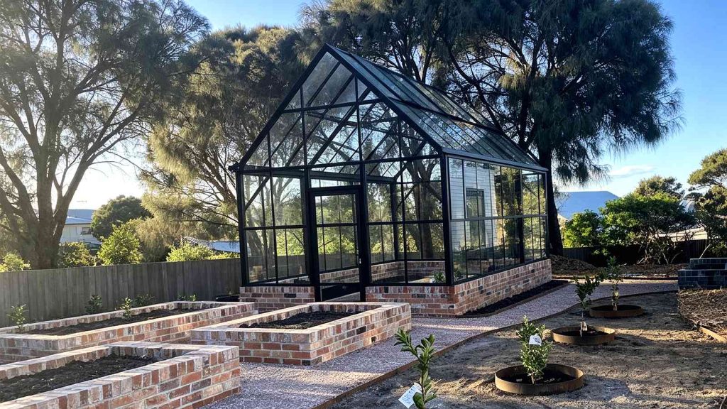 Black frame steel glass conservatory installed in Australian residential backyard garden