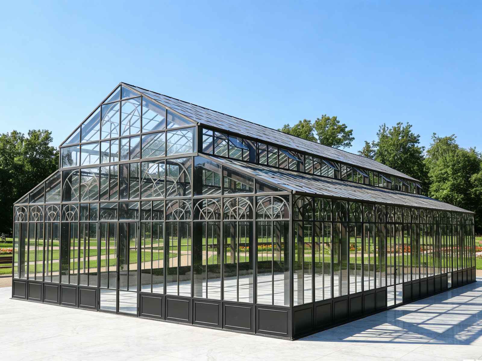 Empty large black steel victorian event conservatory on marble paving in landscaped public park