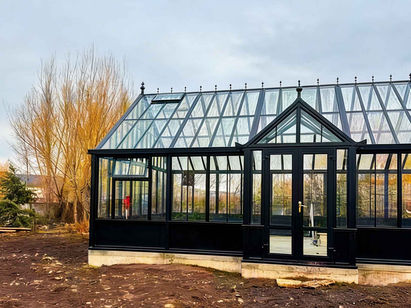 Side‑front angle of victorian black steel glass conservatory greenhouse