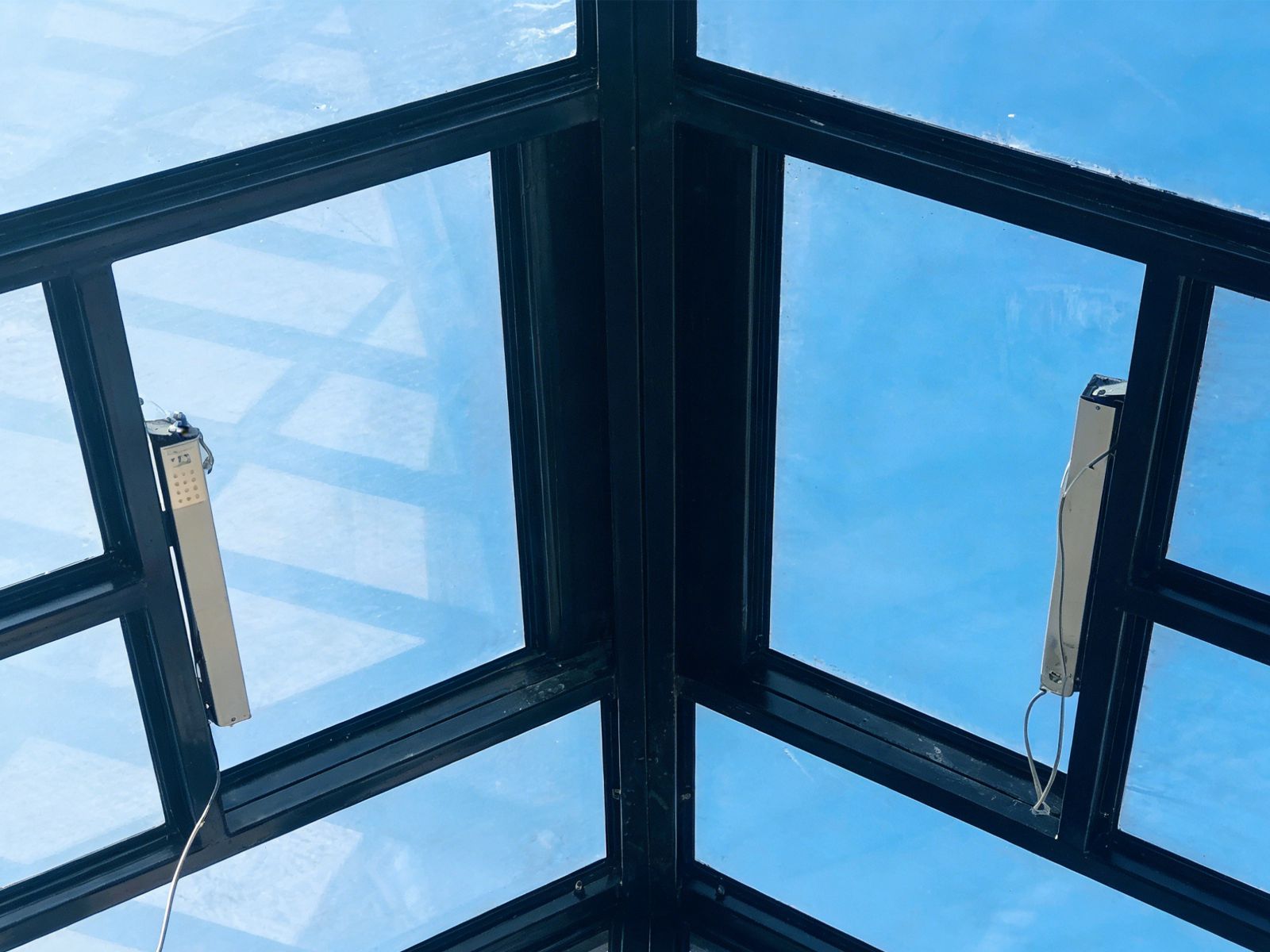 Close‑up of electric window opener actuators inside steel glass conservatory